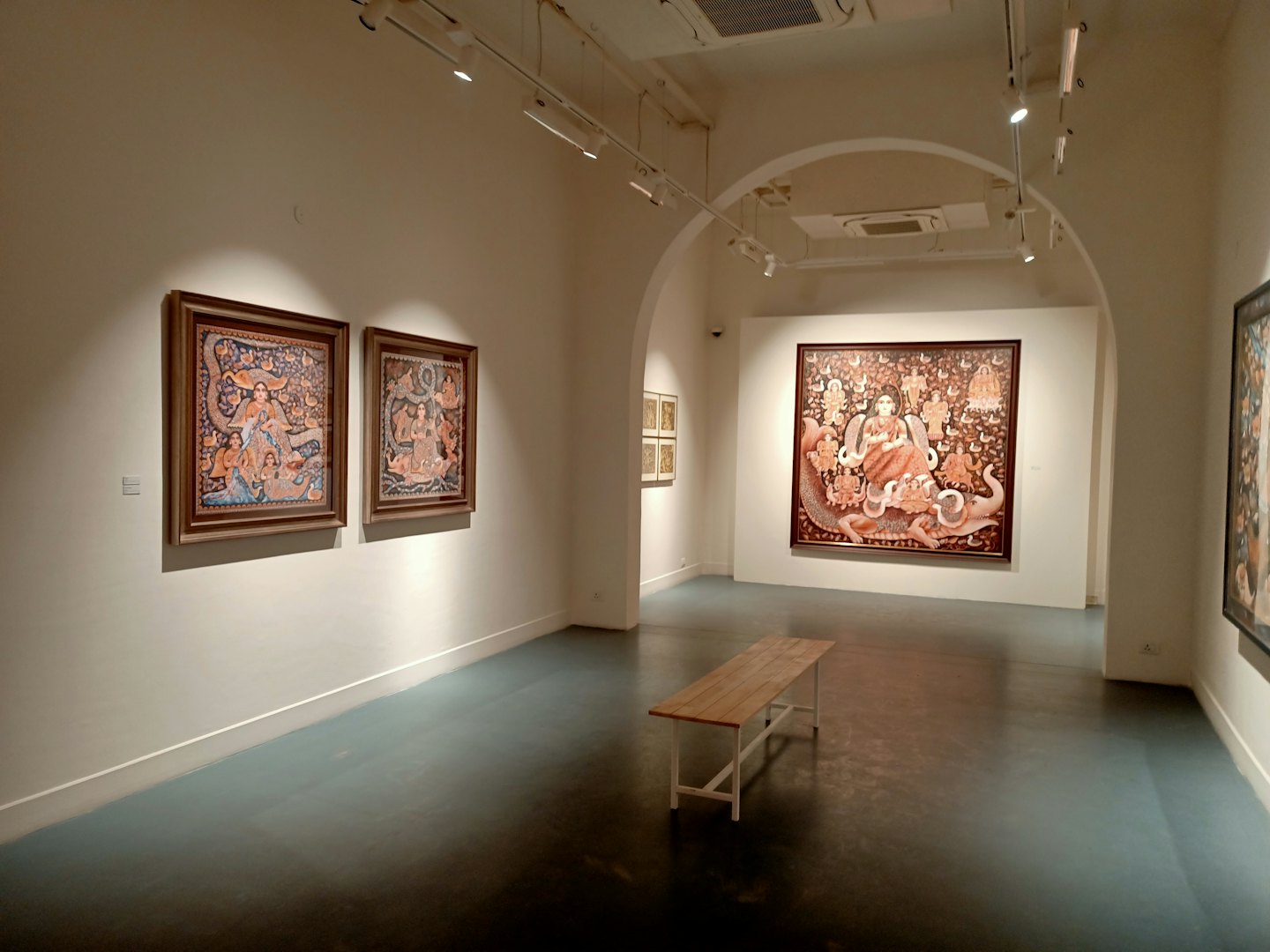 Banco de madera en una galería de arte moderna y blanca.